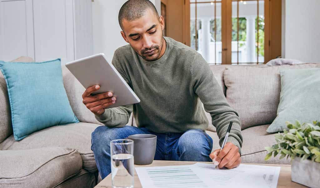 Homeowner Sitting on Couch Checking Contractor References Online